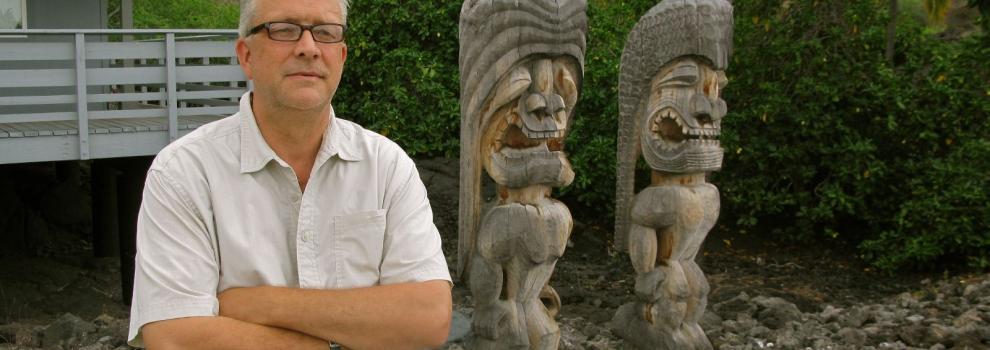 Photo of Sven Kirsten with two carved tikis