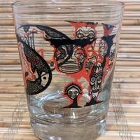 Tiki Kon mai tai glass side view, showing mask illustrations from Pacific Rim cultures