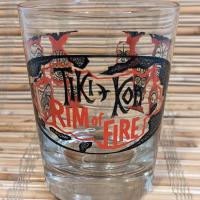 Tiki Kon mai tai glass front view, with the event logo superimposed over a stylized map of the pacific.