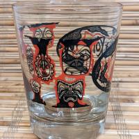 Tiki Kon mai tai glass side view, showing mask illustrations from Pacific Rim cultures